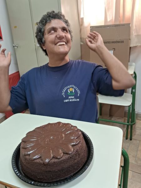 Aluna da APAE Rural de Campo Mourão se emociona ao ser surpreendida com bolo de aniversário, em 08/12/2023.